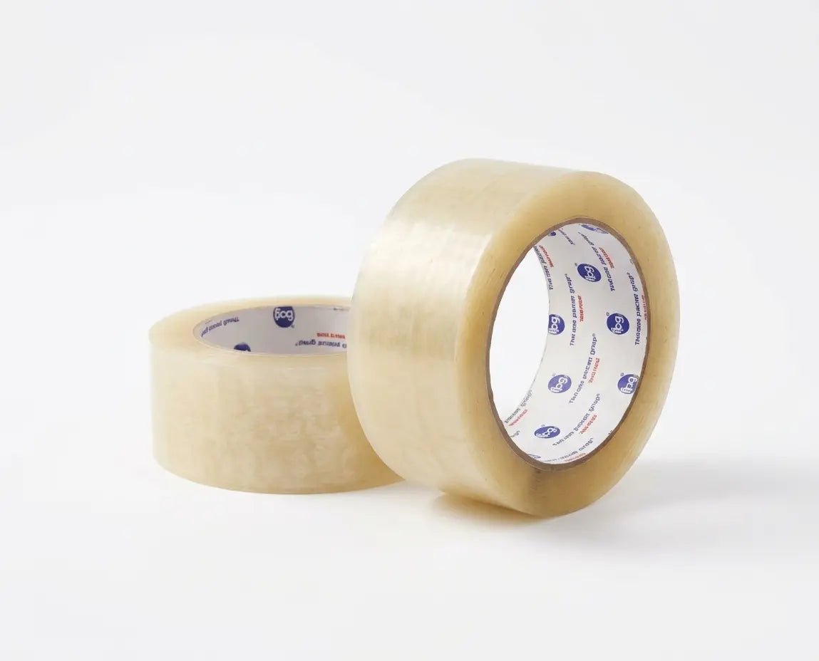 Studio product photograph of two rolls of Intertape Polymer Group (IPG) 6122 Hot Melt clear carton sealing tape, 48mm wide, showing the 'The Strong Silent Group' logo on the core. One roll is upright and one is on its side, isolated on a white background.
